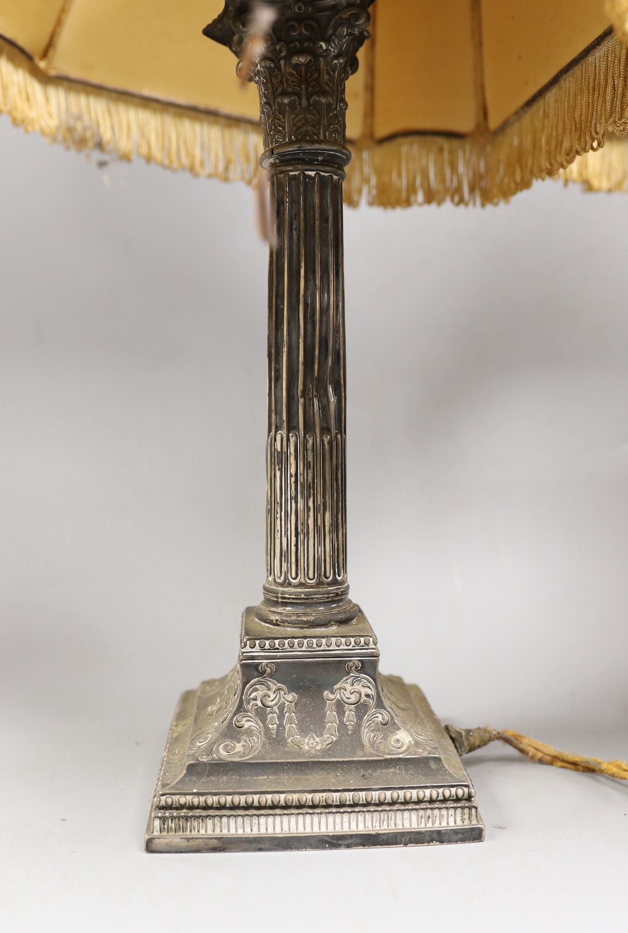 A pair of late Victorian silver Corinthian column candlesticks, now drilled and converted to table lamps, James Dixon & Sons, Sheffield, 1890, weighted, with decorative shades, overall 45cms high.
